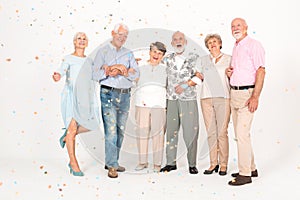 Elegantly dressed elderly people standing in a white room