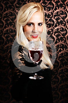 Elegantly dressed light hair model holding a crystal glass