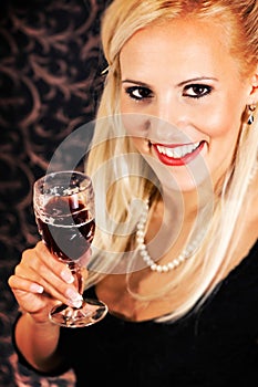 Elegantly dressed light hair model holding a crystal glass