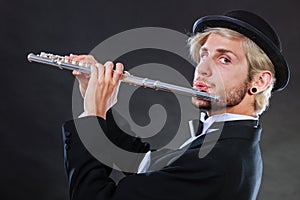 Elegantly dressed male musician playing flute