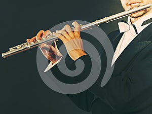 Elegantly dressed male musician playing flute