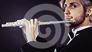 Elegantly dressed male musician playing flute