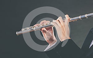 Elegantly dressed male musician playing flute