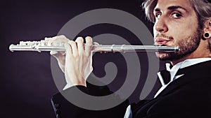 Elegantly dressed male musician playing flute