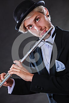 Elegantly dressed male musician playing flute