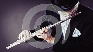 Elegantly dressed male musician playing flute