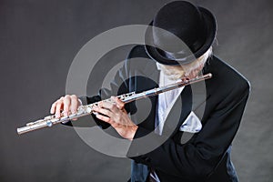 Elegantly dressed male musician playing flute