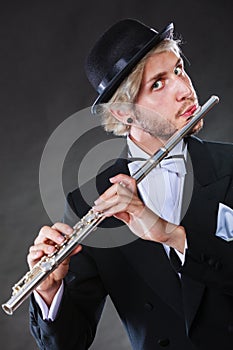 Elegantly dressed male musician playing flute