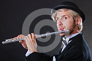 Elegantly dressed male musician playing flute