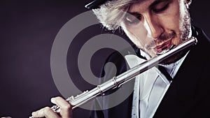 Elegantly dressed male musician playing flute