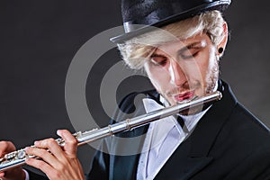 Elegantly dressed male musician playing flute