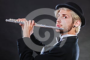 Elegantly dressed male musician playing flute