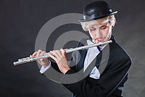 Elegantly dressed male musician playing flute