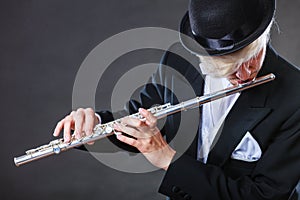 Elegantly dressed male musician playing flute