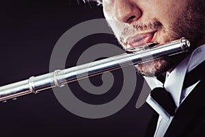 Elegantly dressed male musician playing flute