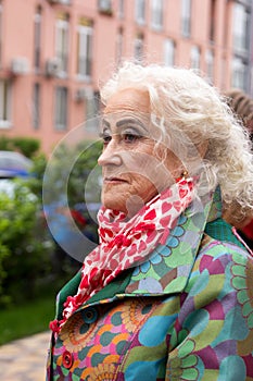 Elegantly dressed old woman outdoors in waiting