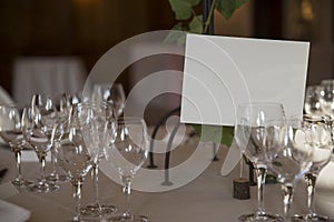 Elegantly served with wedding glasses, cutlery and decorated with flowers tables with white tablecloths and burning candles