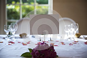 Elegantly served with wedding glasses, cutlery and decorated with flowers tables with white tablecloths and burning candles