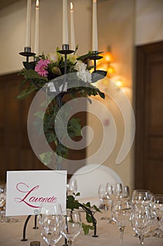 Elegantly served with wedding glasses, cutlery and decorated with flowers tables with white tablecloths and burning candles