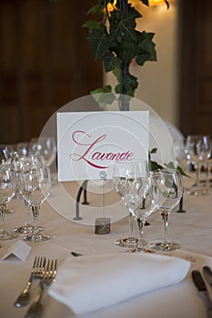 Elegantly served with wedding glasses, cutlery and decorated with flowers tables with white tablecloths and burning candles