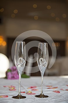 Elegantly served with wedding glasses, cutlery and decorated with flowers tables with white tablecloths and burning candles