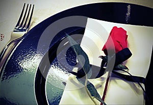 elegantly table with a rose on the black plate