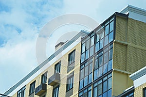 Element of a modern house with a brick facade, glass windows and loggias. Multi-apartment urban residential building photo