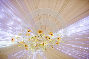 Element of wedding decor flowers and lights on ceiling