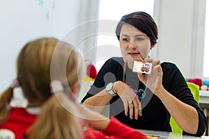 Elementary Age Girl in Child Occupational Therapy Session Doing Playful Exercises With Her Therapist.