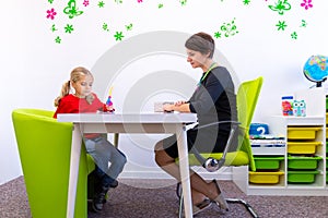 Elementary Age Girl in Child Occupational Therapy Session Doing Playful Exercises With Her Therapist.