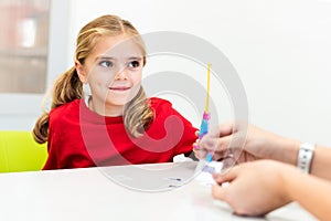 Elementary Age Girl in Child Occupational Therapy Session Doing Playful Exercises With Her Therapist.