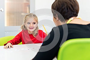 Elementary Age Girl in Child Occupational Therapy Session Doing Playful Exercises With Her Therapist.