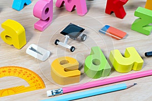 Elementary classroom table with wooden word EDU and education supplies for school background.