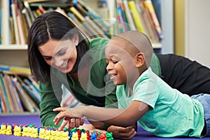 Elementary Pupil Counting With Teacher In Classroom