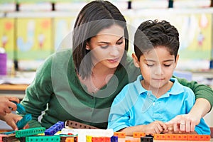 Elementary Pupil Counting With Teacher In Classroom