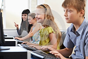 Elementary Pupils In Computer Class With Teacher