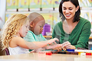 Elementary Pupils Counting With Teacher In Classroom