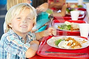 Elementary Pupils Enjoying Healthy Lunch In Cafeteria