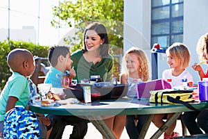 Elementary Pupils And Teacher Eating Lunch