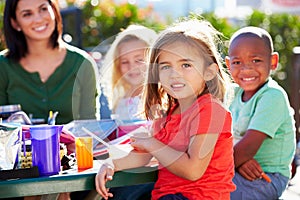 Elementary Pupils And Teacher Eating Lunch