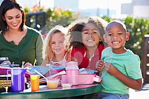 Elementary Pupils And Teacher Eating Lunch