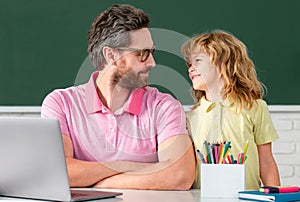 Elementary school boy in classroom on lesson. Teacher explaining to pupil. First day at school. Cute little boy studying