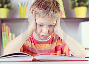 Elementary school boy at desk reading boock