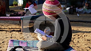 Elementary school boy doing homework outdoor. Poor kids reading book and writing with pencil