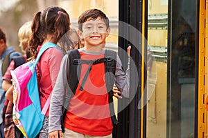 Elementary school boy at the front of the school bus queue