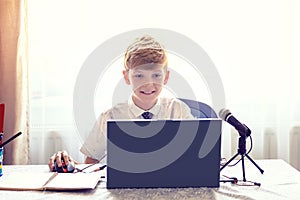 Elementary school boy studying from home with video lesson