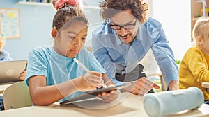 Elementary School Computer Science Class: Cute Girl Uses Digital Tablet Computer, Friendly Teacher