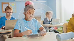 Elementary School Computer Science Class: Cute Girl Uses Digital Tablet Computer, Her Classmates w