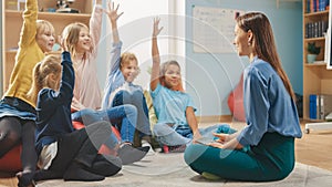 Elementary School Creativity Class: Children Sitting on the Bean Bags while Teacher Explains Lesso