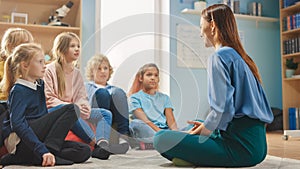 Elementary School Creativity Class: Children Sitting on Carpet while Caring Teacher Explains Lesso